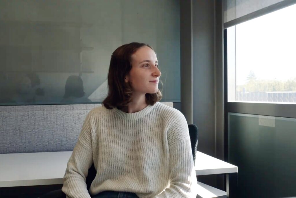 woman sitting in chair looking out a window in an office